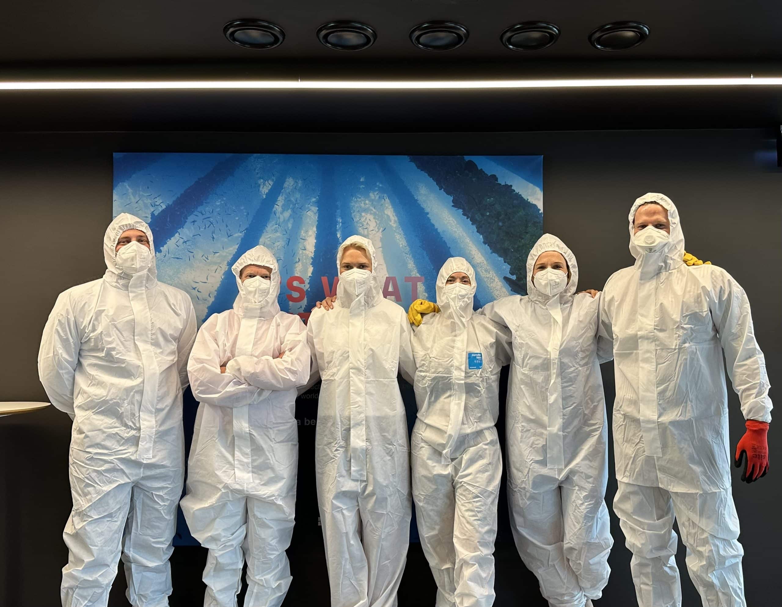 Grieg Green associates dressed up in white protective suits .